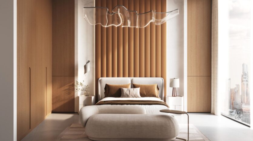 A modern Skyflame bedroom featuring an upholstered accent wall, a white bed with brown and white bedding, a curved bench, minimalist nightstands, a sculptural ceiling light, and large windows offering views of the city.
