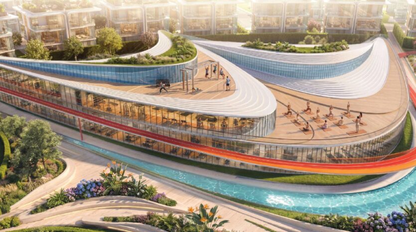 Das moderne, geschwungene Glasgebäude von Greenz by Danube verfügt über einen Fitness- und Yogaraum auf dem Dach, von dem aus man auf angelegte Gärten, einen gewundenen Weg und einen schmalen blauen Pool oder ein Wasserbecken blickt, mit modernen Häusern im Hintergrund.