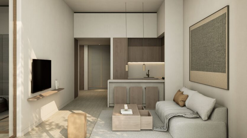 The minimalist living room features light wood furniture, a wall-mounted TV, a beige sofa with beige cushions, a simple coffee table, and a kitchen with wood cabinets and bar stools for breakfast. The JAD288 harmoniously blends styles in an open space.