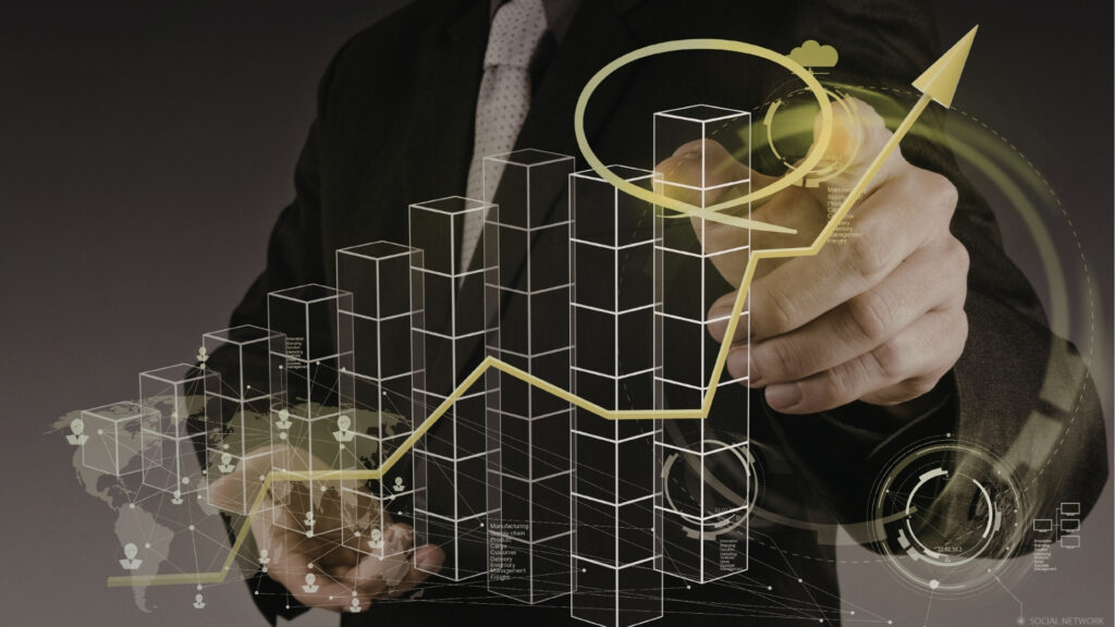 A person in a suit draws an upward-pointing yellow arrow on a transparent screen displaying digital bar charts and futuristic data visualizations, symbolizing the success of real estate transactions and business growth.