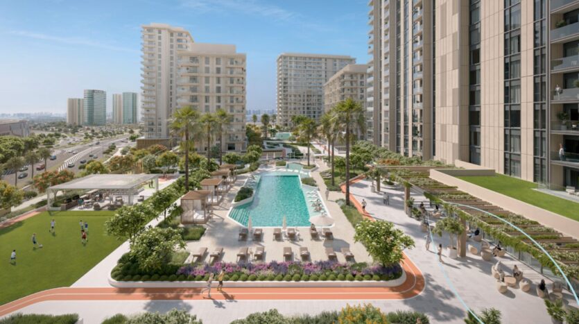 Tara Park est un complexe d'appartements moderne avec de grands bâtiments, une piscine centrale, des chaises longues, des palmiers, des jardins paysagers, une piste de jogging et une pelouse verte où les gens jouent et se détendent par une journée ensoleillée.