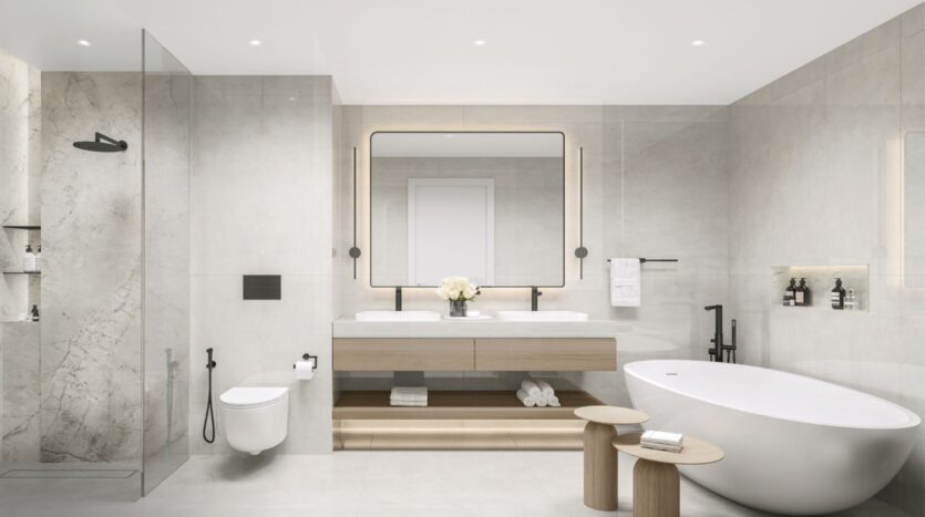 Salle de bains moderne à Tara Park comprenant une douche en verre, des toilettes murales, un meuble à double lavabo avec un grand miroir, une baignoire autoportante, deux petits tabourets en bois, et des murs et sols carrelés de couleur neutre.