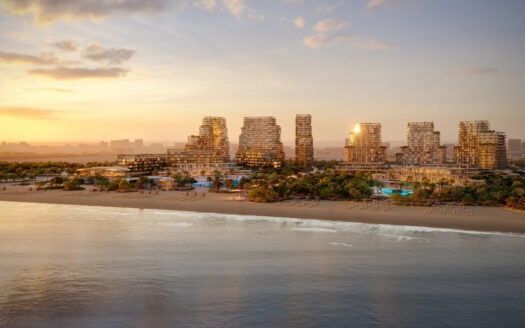 In the heart of Dubai's real estate market, a modern beachfront complex, with its glass towers and lush vegetation, lights up at sunset as the golden light reflects off the calm water. Sun loungers line the sandy beach along the tranquil shoreline.