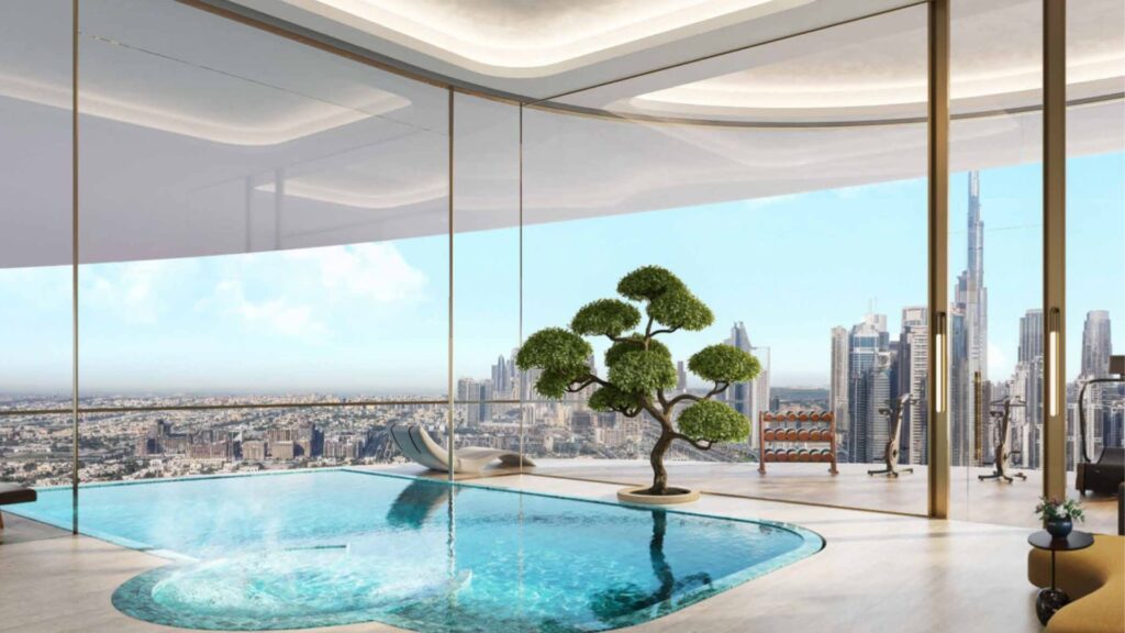 La lujosa piscina cubierta de las residencias Amali, adornada con un bonsái, ofrece vistas al horizonte de la ciudad a través de ventanas que van del suelo al techo, con modernos rascacielos y un cielo azul cristalino.