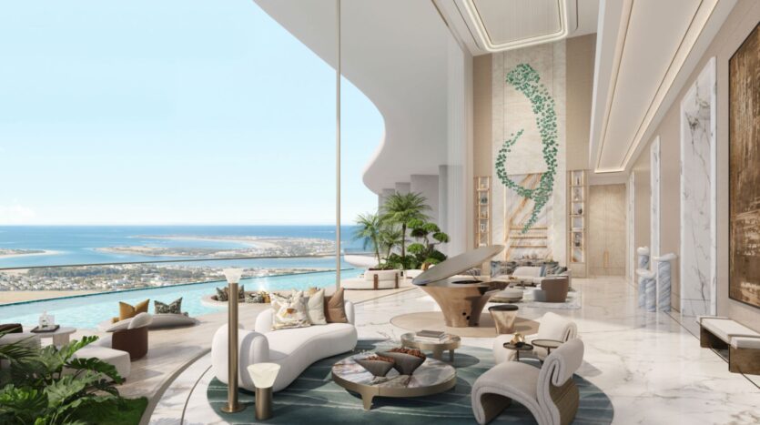 Lujoso y moderno salón de las residencias Amali, con suelos de mármol, muebles elegantes, un piano de cola, grandes ventanales con vistas al océano y una gran pared decorada con obras de arte abstractas y plantas. La luz natural inunda este espacio diáfano.