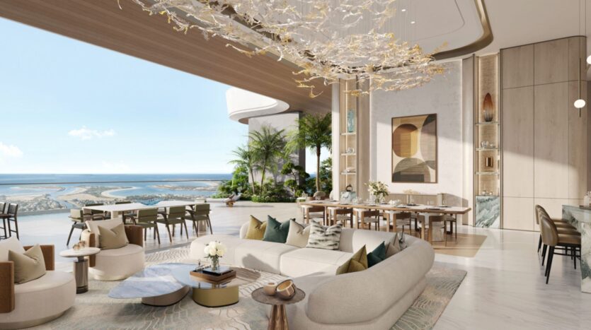 Lujoso salón-comedor diáfano en las residencias Amali, con una decoración moderna, una elegante lámpara de araña, mullidos sillones, amplios ventanales, plantas de interior y unas amplias vistas al océano al fondo.