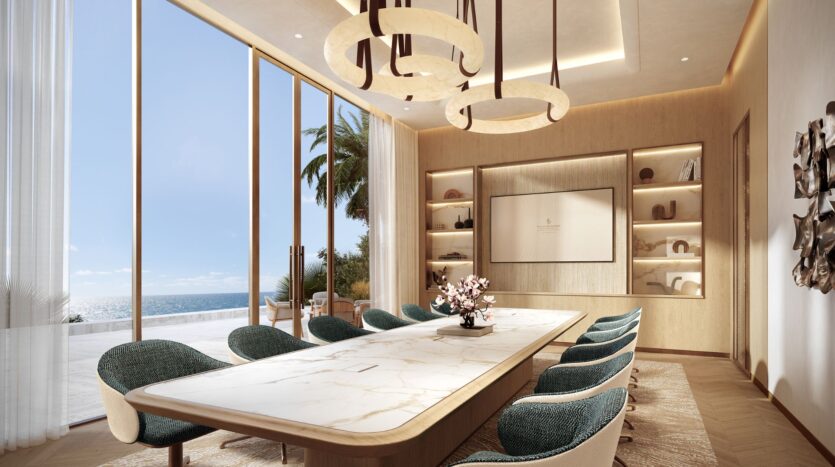 The modern conference room at Four Seasons Private Residences features a marble table, teal chairs, built-in shelves, large windows overlooking the ocean, and circular pendant lights hanging from the ceiling.
