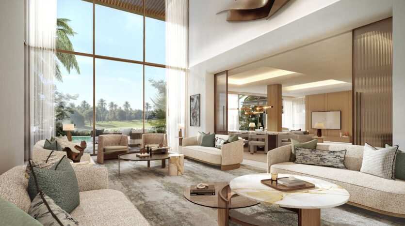 A spacious, modern living room in the Four Seasons private residences, featuring floor-to-ceiling windows, neutral-toned sofas, a marble coffee table, and outdoor greenery. The open-concept layout leads to a well-lit dining room with contemporary décor.