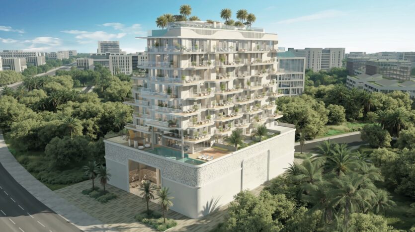 Un immeuble moderne de plusieurs étages avec des balcons et des jardins sur les toits, entouré d'arbres luxuriants et de verdure, se dresse dans la ville de Meriden, avec d'autres bâtiments visibles à l'arrière-plan.