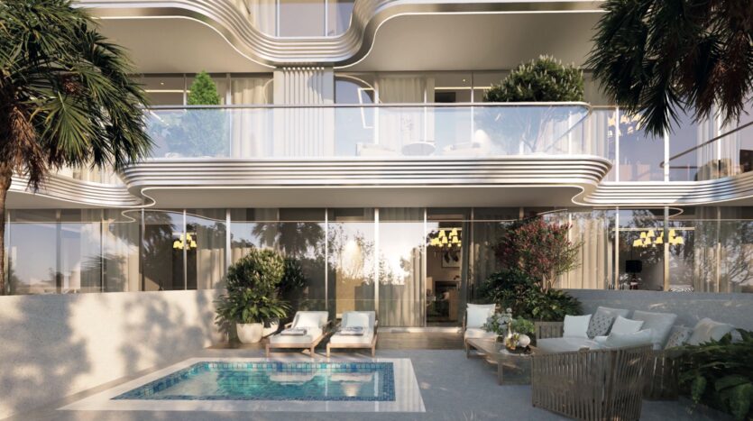 Appartement de luxe moderne aux Meriden Beach Residences avec des balcons incurvés, des fenêtres allant du sol au plafond et un patio doté d'une petite piscine, de chaises longues, de plantes luxuriantes et d'un confortable coin salon extérieur entouré de verdure.