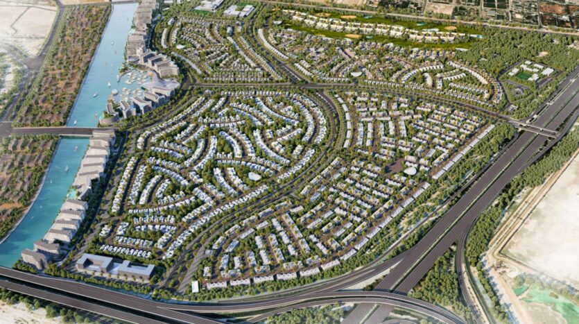 Aerial view of River Cove Residences, a large, modern neighborhood featuring winding streets, clusters of homes, lush green spaces, a stream on the left, and major highways running along the right and bottom edges of the area.