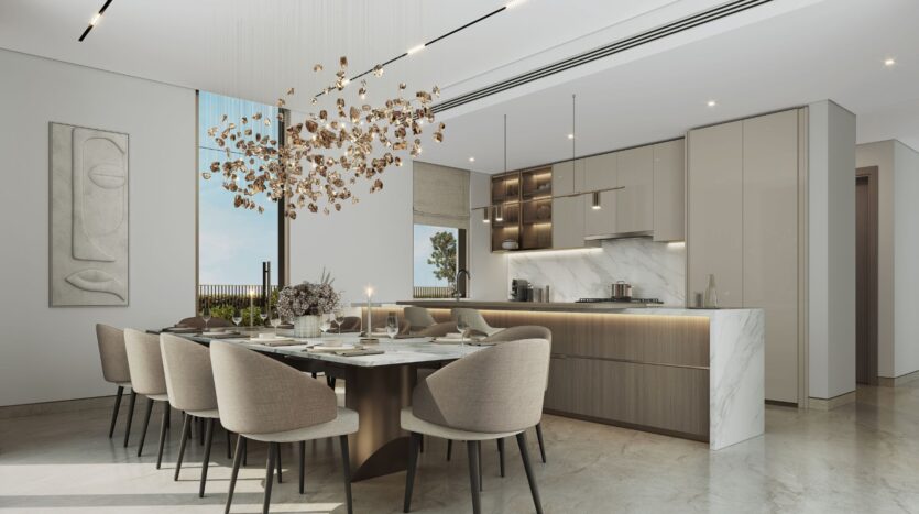 Das moderne Esszimmer und die Küche von „The Orchard by Sobha“ mit einer Marmor-Kochinsel, Möbeln mit klaren Linien, einem großen Tisch für acht Personen, eleganten beigen Stühlen, einem skulpturalen goldenen Kronleuchter und minimalistischen Wandkunstwerken – alles in neutralen Farbtönen und bei Tageslicht.