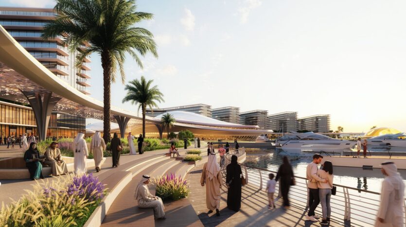 People wearing both traditional and modern clothing stroll and relax along a waterfront promenade near The Terraces by Sobha, with yachts, palm trees, and modern buildings in the background, under a sunny sky.