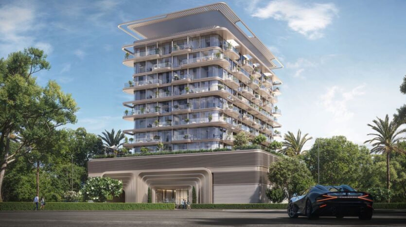 A modern multi-story building with large balconies and lush greenery is surrounded by trees and palm trees. In the foreground, a sleek sports car is parked under a clear blue sky, reflecting the luxury of The Tides by Amis.