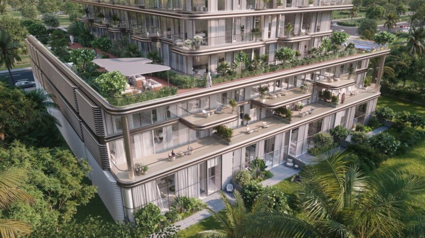 A modern multi-story building, The Tides by Amis hotel features large floor-to-ceiling windows, spacious balconies, and lush greenery. The outdoor seating areas and terraces are surrounded by greenery and palm trees.