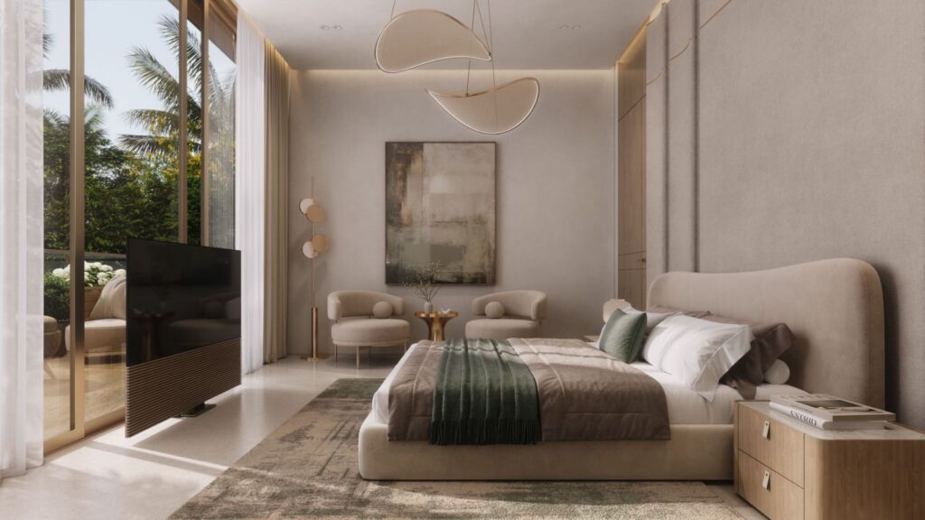 The modern bedroom at The Tides by Amis features a plush bed, a green throw blanket, two armchairs, abstract wall art, large windows with sheer curtains, a flat-screen TV, and a view of palm trees. The neutral tones create a comfortable and elegant atmosphere.