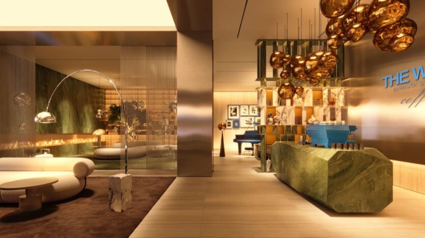 Un salon moderne et luxueux dans la tour Wow avec un éclairage doré, des surfaces en marbre vert, un piano bleu, des œuvres d'art abstraites et des sièges en peluche. Des cloisons en verre et des lumières sculpturales créent une ambiance élégante et sophistiquée.