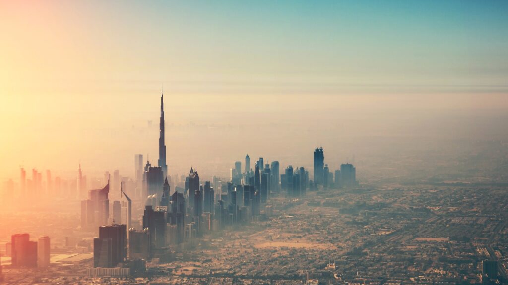 Vue aérienne de la ligne d'horizon de Dubaï au lever du soleil, avec le Burj Khalifa dominant les autres gratte-ciel - une vue impressionnante qui reflète la croissance montrée dans marché immobilier de Dubaï chiffres mars 2026 comme la ville s'étend vers un horizon brumeux et doré.