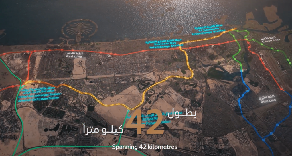Mappa aerea di Dubai con le linee della metropolitana: la linea rossa, la linea verde e la nuova linea Gold della metropolitana di Dubai, che si estende per 42 chilometri, con le indicazioni in inglese e in arabo; in alto sono visibili il Palm Jumeirah e la costa.