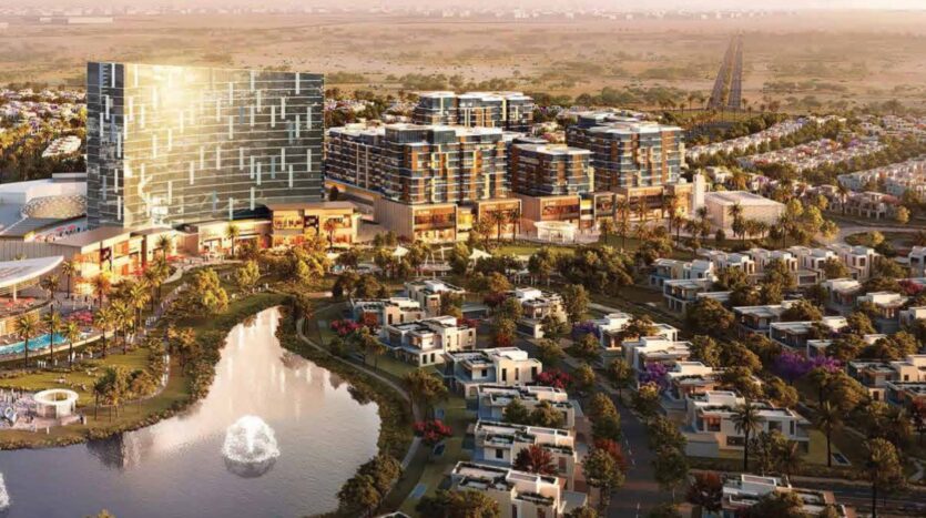 Vue aérienne de Calisi by Zoya, un développement urbain moderne comprenant des immeubles de grande hauteur, des villas, un étang avec une fontaine, des espaces verts et des routes, avec en arrière-plan un paysage suburbain et désertique tentaculaire.