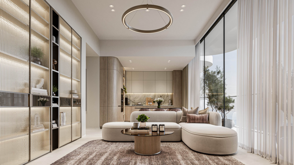 Un salon moderne avec un canapé blanc incurvé, une table basse ronde et des étagères ouvertes doucement éclairées. De grandes fenêtres allant du sol au plafond avec des rideaux transparents inondent l'espace de lumière. Le coin cuisine et l'œuvre d'art Cybele by Wadan sont visibles à l'arrière-plan.