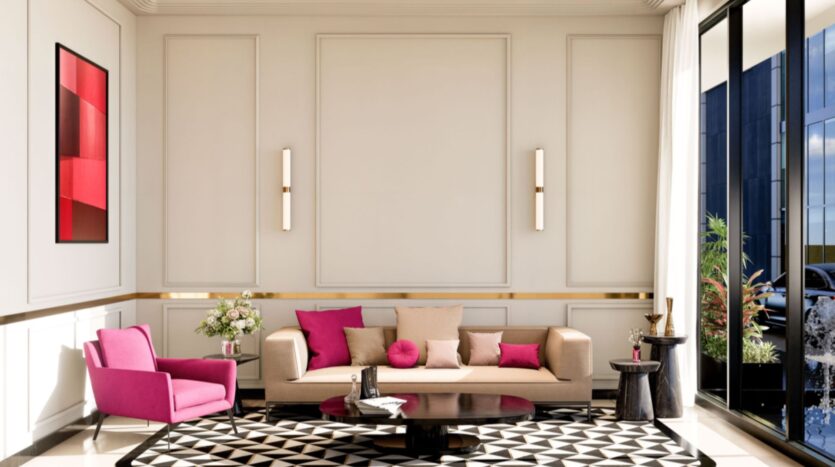 Le salon moderne de la résidence Fauchon est composé d'un canapé beige, d'un fauteuil rose, de coussins roses et beiges, d'un tapis géométrique noir et blanc, d'une œuvre d'art abstraite rouge, de deux appliques murales, d'une table basse ronde et de fenêtres allant du sol au plafond.