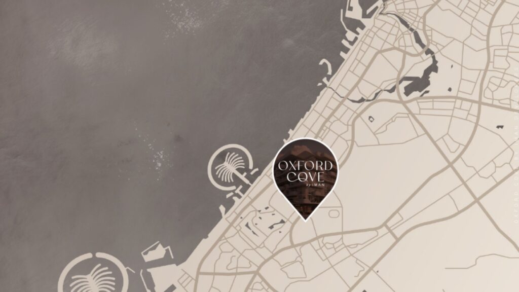 Une carte beige et grise met en évidence une zone côtière avec une épingle de localisation étiquetée "Oxford Cove by Iman". Des palmiers emblématiques bordent l'eau et des rues aux contours flous sillonnent le territoire.