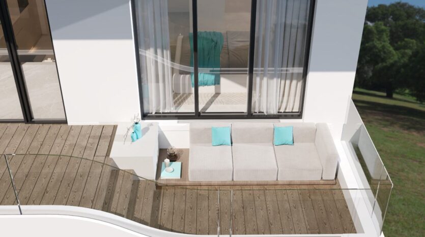 Un balcon moderne avec une balustrade en verre et un design inspiré du Reef 996, comprenant un canapé blanc en forme de L avec des coussins turquoise, une petite table d'appoint et un sol en bois, adjacent à une grande fenêtre donnant sur une zone herbeuse.
