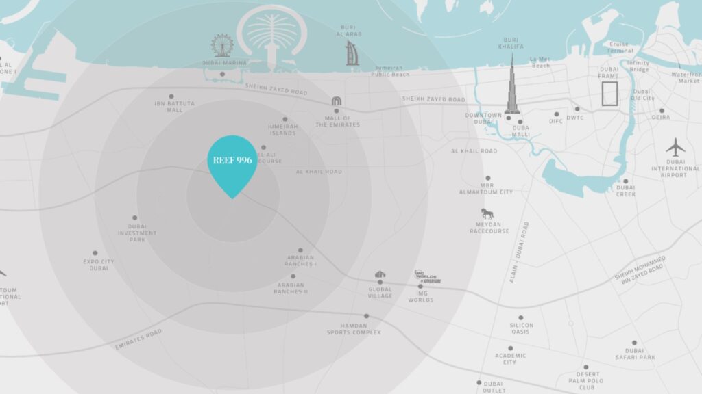 Une carte stylisée de Dubaï met en évidence l'emplacement "Reef 906" avec un marqueur bleu, à proximité de points de repère tels que Reef 996, l'aéroport international de Dubaï, Palm Jumeirah, Expo City, ainsi que des routes principales et des attractions locales.