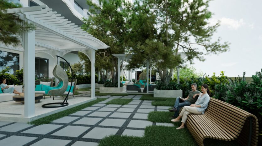 Un espace extérieur aménagé avec un banc moderne Reef 996, une pergola, des fauteuils suspendus et des arbres. Deux personnes s'assoient sur le banc, tandis que d'autres se détendent sous la pergola. L'espace est agrémenté de chemins pavés et d'une végétation luxuriante.