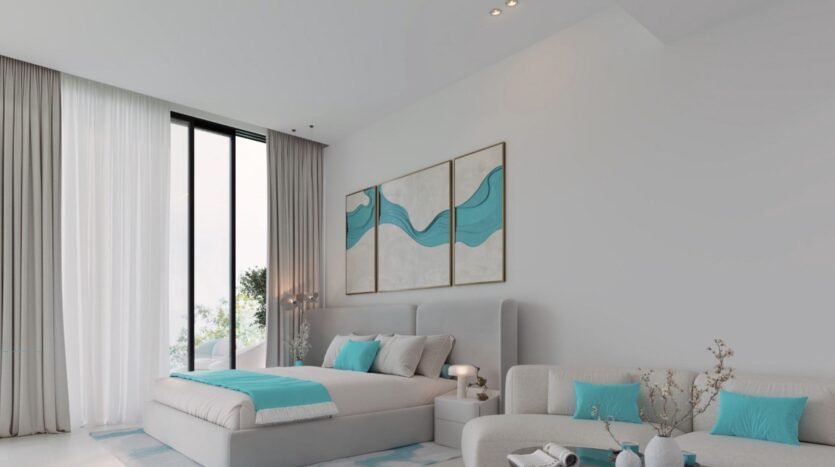 Chambre à coucher moderne avec une grande fenêtre, des meubles gris clair et des accents sarcelle dans le style de Reef 996. Le lit est orné d'oreillers et d'une couverture de couleur sarcelle, avec une œuvre d'art abstraite de couleur sarcelle au-dessus. Un petit canapé et une table basse complètent l'espace naturellement éclairé.