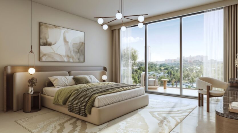 Chambre à coucher moderne à Rotana Residences avec un grand lit, de l'art abstrait, des lampes suspendues et des plafonniers, un bureau et une chaise. Les fenêtres du sol au plafond révèlent les arbres, l'eau et les bâtiments de la ville au-delà du balcon.