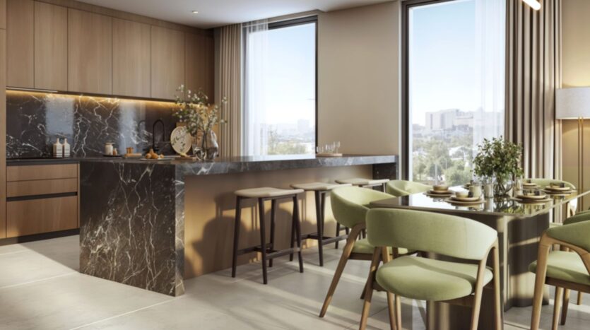 Cuisine et salle à manger modernes dans les résidences Rotana, avec des armoires en bois, des comptoirs et un îlot en marbre noir, des chaises vertes rembourrées, de grandes fenêtres avec vue sur la ville et un décor aux couleurs neutres.
