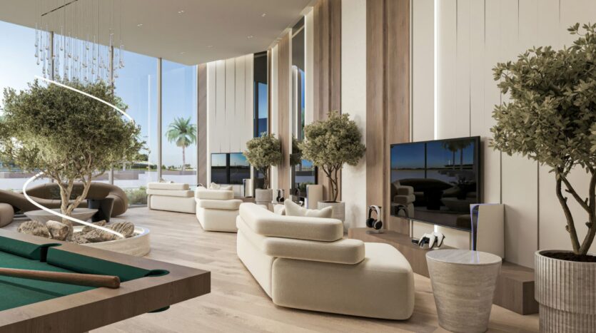 Un salon moderne et luxueux au Sakura Gardens avec des canapés couleur crème, de grandes fenêtres, des arbres d'intérieur, une télévision à écran plat, une table de billard et des vues sur les palmiers à l'extérieur, le tout avec des planchers en bois clair et des panneaux muraux verticaux.