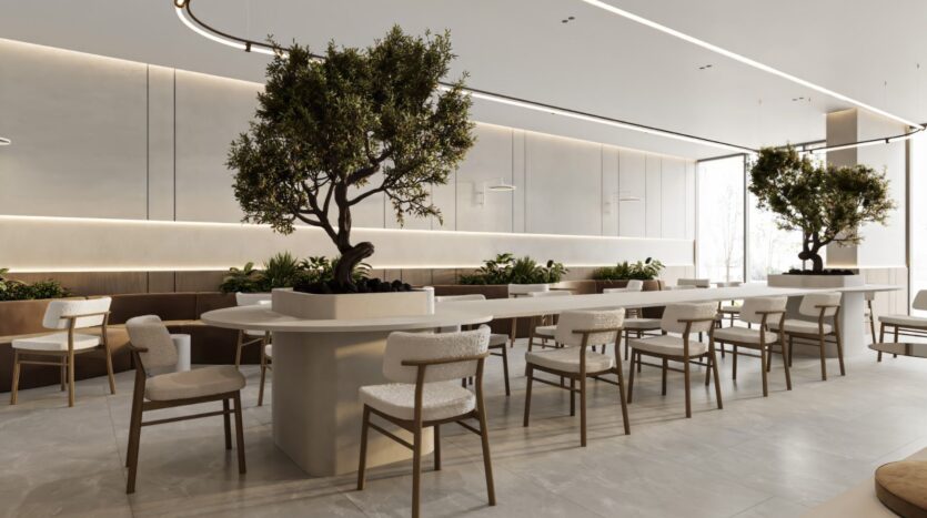 Salle à manger moderne et minimaliste du Sakura Gardens, avec des tables et des chaises de couleur claire, de grandes plantes en pot en guise de centre de table, des murs neutres et la lumière naturelle qui pénètre par les fenêtres. Le cadre est lumineux, aéré et accueillant.