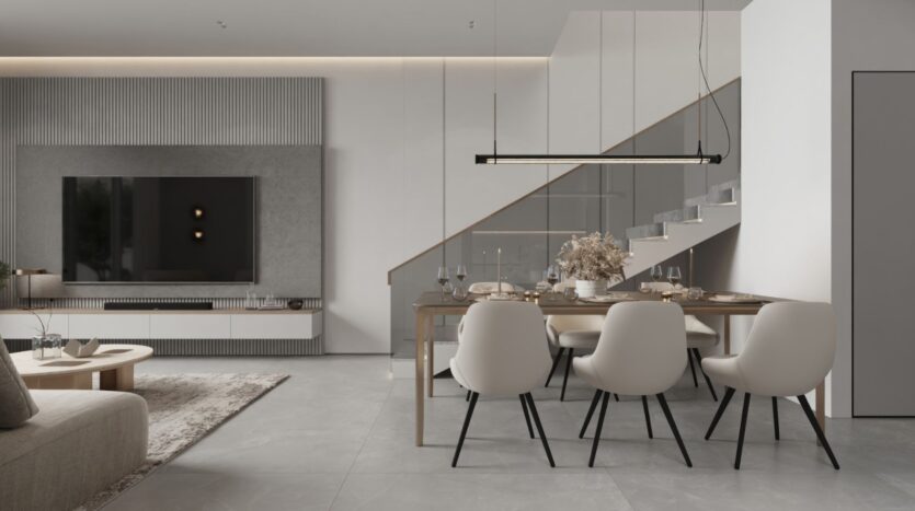 Un salon et une salle à manger modernes et minimalistes avec des tons neutres, un mobilier épuré et une élégance inspirée des jardins de Sakura. Vous y trouverez une grande télévision murale, une table à manger pour six personnes et un escalier avec une rampe en verre en arrière-plan.