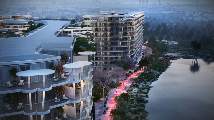 Des gratte-ciel modernes aux balcons incurvés surplombent un front de mer, entouré d'arbres et éclairé par des lampadaires au crépuscule, près des jardins de Sakura, avec une ligne d'horizon de la ville visible dans le lointain brumeux.