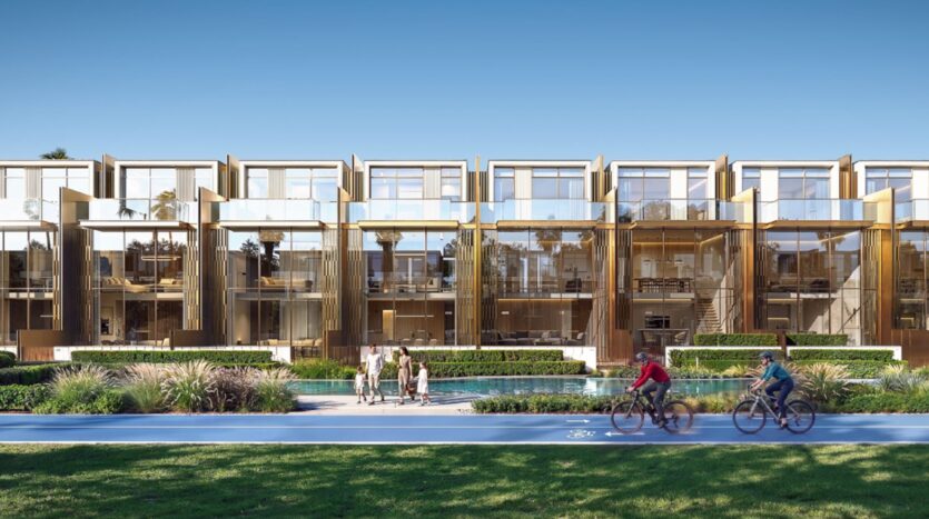 Tilal by Binghatti est un complexe d'appartements modernes avec de grandes baies vitrées et des balcons, avec des espaces verts, une piscine réfléchissante et des gens qui marchent et font du vélo sur un sentier bleu sous un ciel bleu clair.