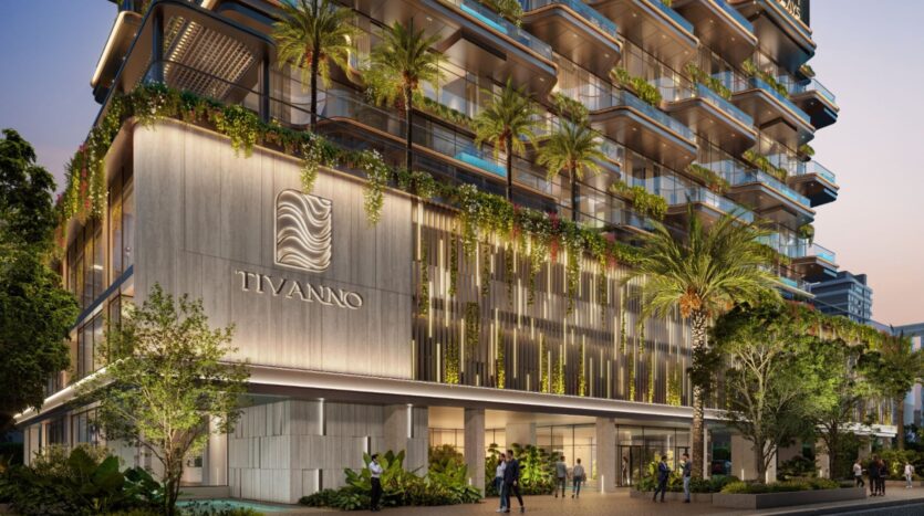 Un bâtiment moderne de plusieurs étages nommé Tivanno par AYS présente une verdure luxuriante sur les balcons, des accents lumineux verticaux et des personnes marchant près de l'entrée dans une rue bordée d'arbres au crépuscule.