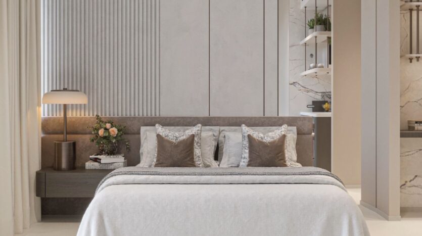 Une chambre à coucher moderne avec un lit bien fait, des draps blancs et des oreillers décoratifs, une table de chevet avec une lampe et un vase de fleurs, et des panneaux muraux gris clair minimalistes, voilà le décor parfait pour Tresora by Wadan.