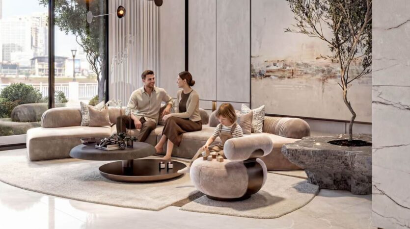 Un salon moderne avec un homme et une femme assis sur un canapé beige, discutant, tandis qu'un enfant joue avec des cubes en bois sur une chaise ronde. De grandes fenêtres et des œuvres d'art créent l'ambiance lumineuse et élégante de Tresora by Wadan.