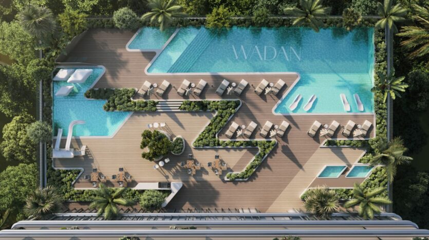 Vue aérienne d'une piscine moderne sur le toit de Tresora by Wadan, avec une terrasse en bois en zigzag, des chaises longues, des parasols, une végétation luxuriante et une grande piscine portant l'inscription "WADA", le tout entouré d'arbres verdoyants.
