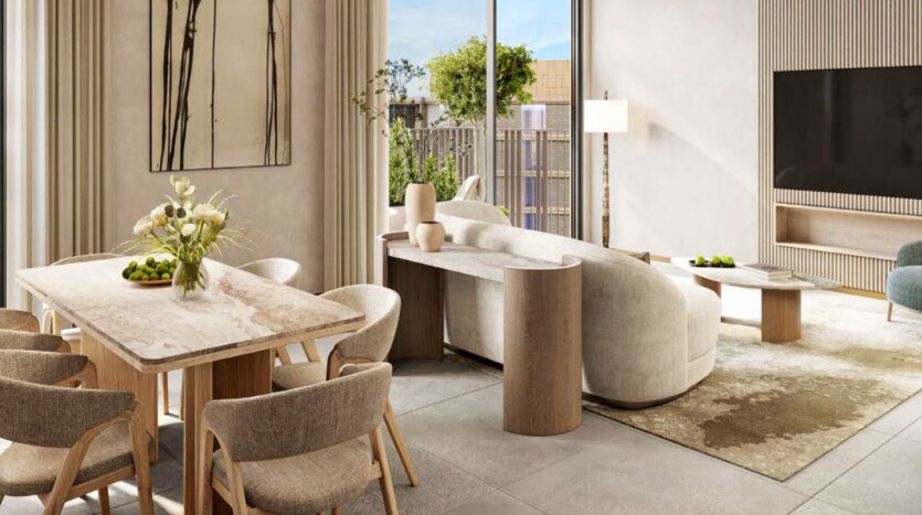 Salon et salle à manger modernes à Arancia Yards by Beyond, avec des tons neutres, une table et des chaises en marbre, un canapé blanc incurvé, de grandes fenêtres, des plantes d'intérieur, des œuvres d'art murales, une télévision et la lumière naturelle qui pénètre.
