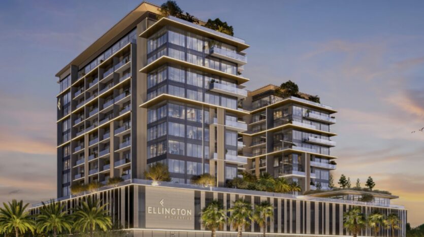 Immeuble moderne de plusieurs étages avec des façades vitrées, des balcons et un toit végétalisé, arborant le nom « Everly Place by Ellington » sur la façade ; entouré de palmiers au coucher du soleil.