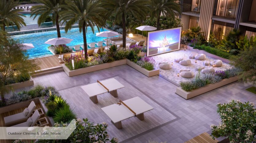L'espace extérieur moderne de l'Everly Place by Ellington comprend une piscine avec des chaises longues, un écran de cinéma en plein air sur lequel est projeté un film, des poufs posés sur le sable, des palmiers, des parasols et des tables de ping-pong, le tout au milieu d'une végétation luxuriante.