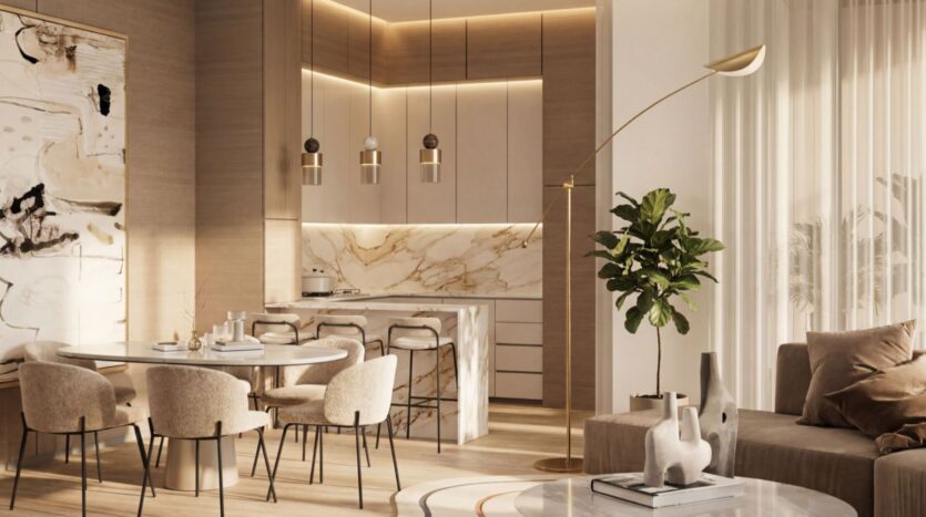 La cuisine ouverte et la salle à manger, modernes et élégantes, de Lunaya Terraces se caractérisent par des tons beiges, des plans de travail en marbre, des suspensions lumineuses, une table à manger ronde avec des chaises, un canapé confortable, une grande plante et de grandes fenêtres ornées de voilages.