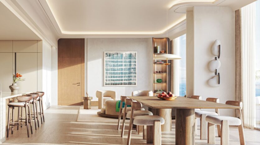 Espace cuisine-salle à manger moderne au Soma Residences, avec un mobilier en bois clair, des tabourets de bar, une grande table en bois, des chaises aux tons neutres, des œuvres d'art murales, des étagères décoratives, de grandes fenêtres et une lumière naturelle abondante.