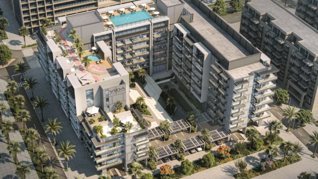 Vue aérienne de Vida Residences Saadiyat Island, un complexe d'appartements modernes avec des balcons, une piscine sur le toit, des cours paysagées et des rues bordées de palmiers. Le bâtiment présente une architecture contemporaine et des espaces de loisirs extérieurs.