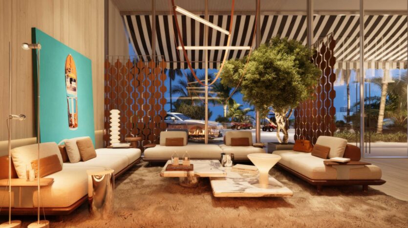 Le salon moderne et élégant de la Villa Del Garda se compose de canapés aux tons neutres, d'une table basse en marbre, d'un grand arbre d'intérieur, d'un plafond rayé et de grandes fenêtres donnant sur les palmiers et les voitures garées à l'extérieur au crépuscule.