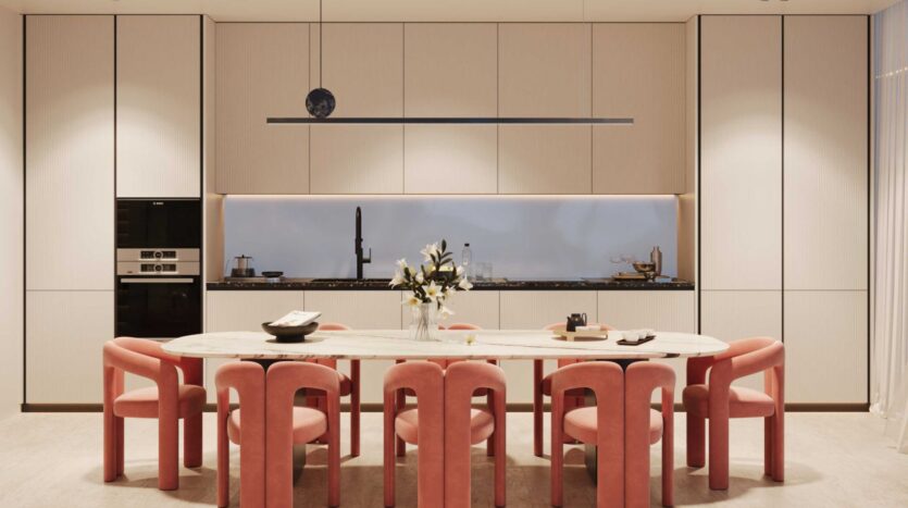 Cuisine moderne à la Villa Del Garda avec une table à manger en marbre entourée de six chaises roses. Des armoires minimalistes, des appareils encastrés, des fleurs fraîches et un éclairage doux sous les armoires créent un look propre et élégant.